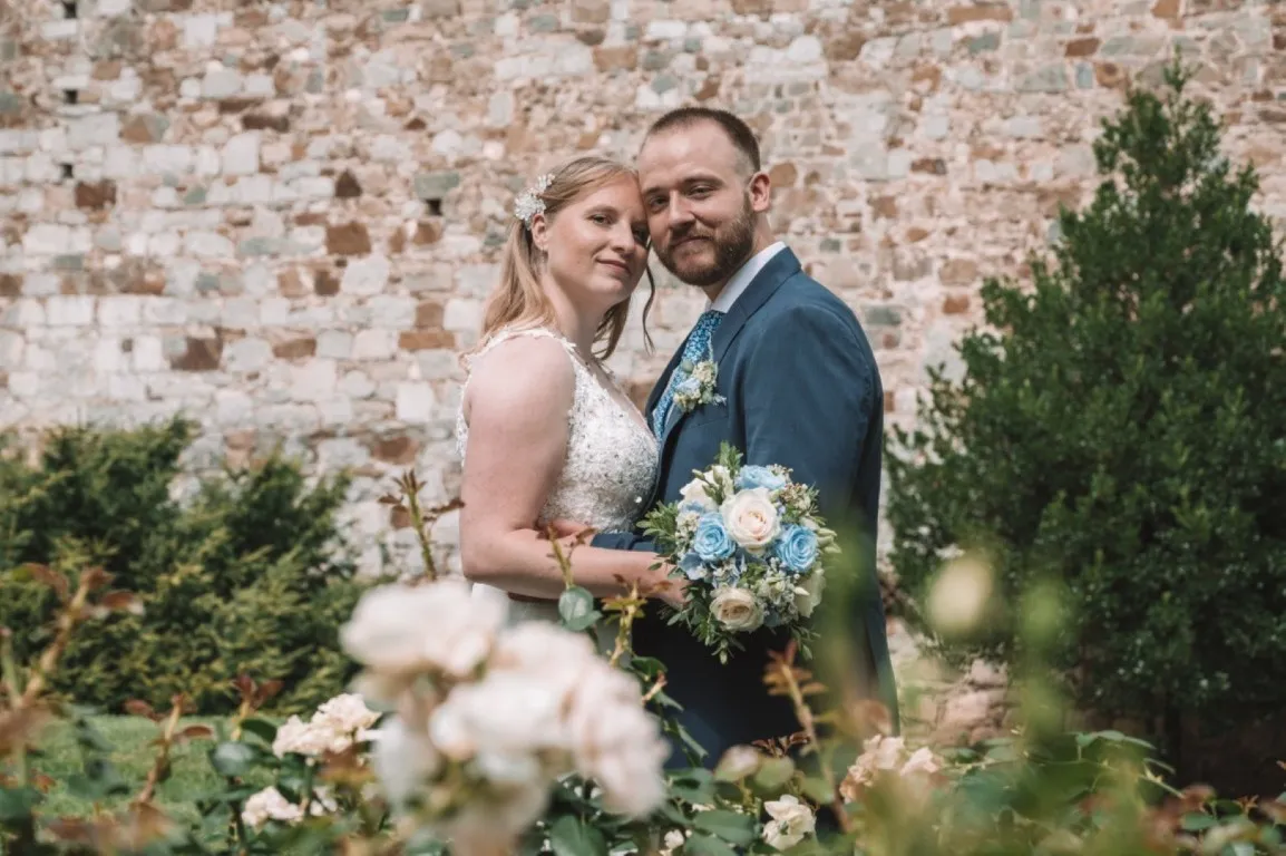 Poročna fotografija mladoporočencev; ujet pristen trenutek z naravno svetlobo in umirjeno kompozicijo v dokumentarnem slogu.